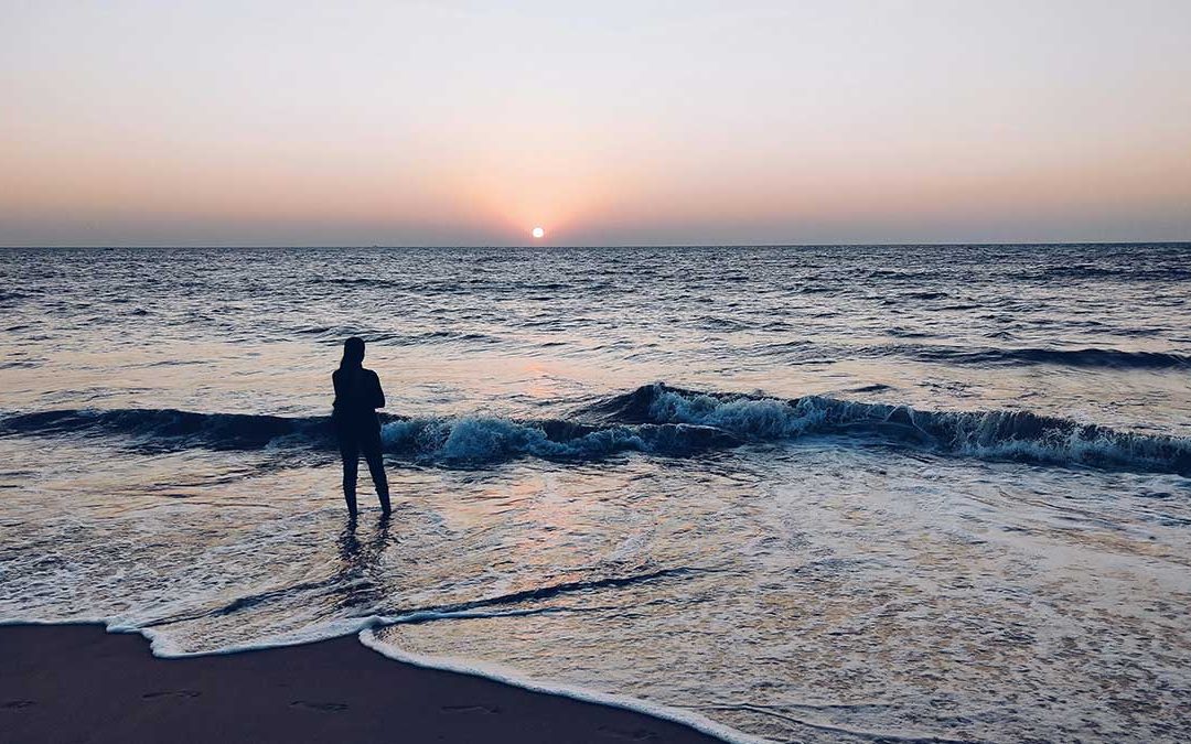 woman standing at the beach, waiting, hesitating
