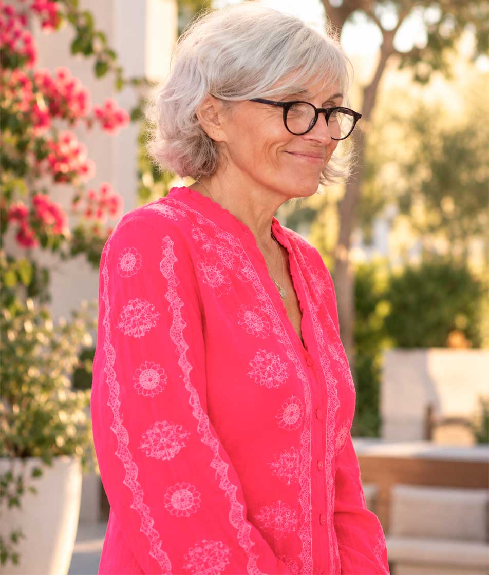 Smiling woman in a lush California garden.